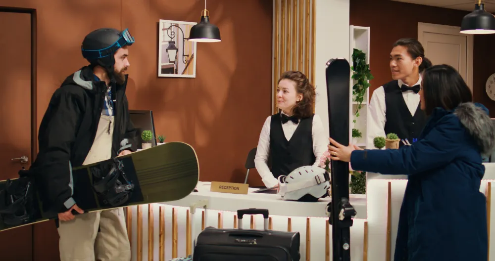 Urlauberpaar steht an der Rezeption eines Hotels